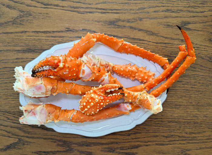 King Crab Legs on a white plate with a wooden background