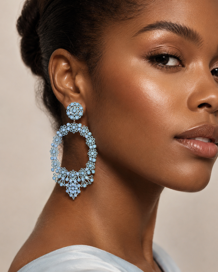 1. Immagine prodotto frontale
Light blue oval lace-inspired earrings with Swarovski crystals and enamelled metal laminae, INGA Sirmione.

2. Immagine sul manichino
Light blue oval statement earring shown on mannequin to illustrate real proportions and size.

3. Immagine editoriale indossata
Close-up editorial portrait of a model wearing light blue oval lace earrings with Swarovski crystals.