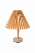 Small table lamp with pleated beige shade on a white background